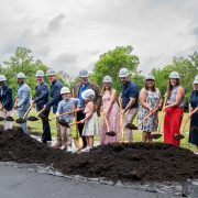 A line of people in hard hats hold gold shovels over a mound of soil at the Memphis Zoo groundbreaking for Stingrays at Mangrove Cove.