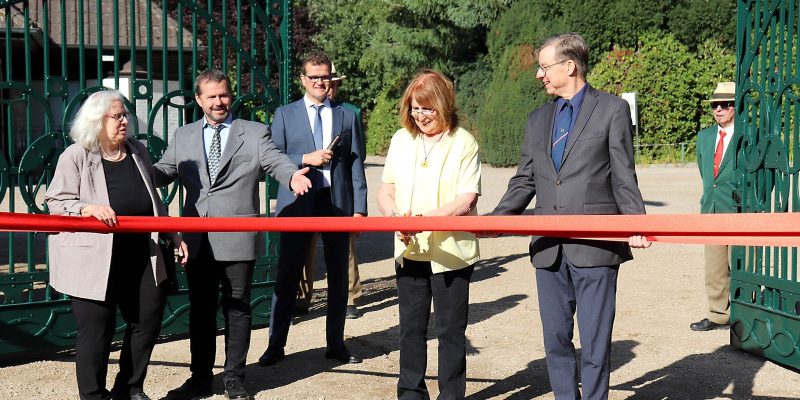 People cutting a ribbon in front of the rebuilt Art Nouveau entrance gate at Tierpark Hagenbeck