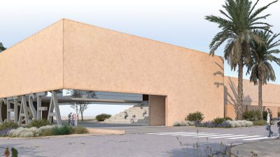 An architect's render of a long, low, sand-colored building with a wide open passage cut through its center, the word CETASEA in freestanding letters on the landscaping in front of it, palms and pine trees around it and a few small figures walking toward the entrance.