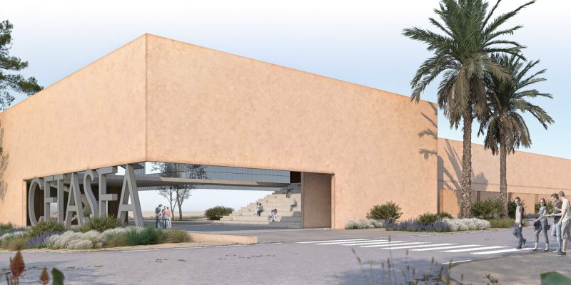 An architect's render of a long, low, sand-colored building with a wide open passage cut through its center, the word CETASEA in freestanding letters on the landscaping in front of it, palms and pine trees around it and a few small figures walking toward the entrance.