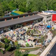 Aerial view of the Elmwood Park Zoo welcome center and veterinary health center with a crowd of visitors on the plaza below