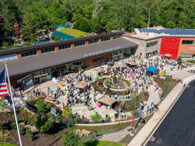 Aerial view of the Elmwood Park Zoo welcome center and veterinary health center with a crowd of visitors on the plaza below
