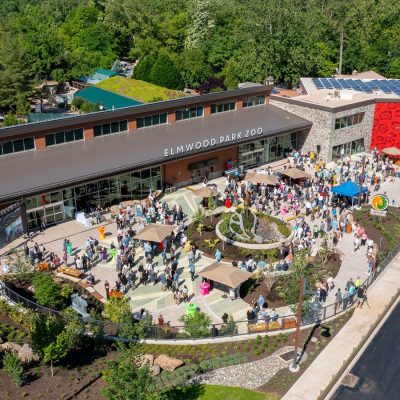 Aerial view of the Elmwood Park Zoo welcome center and veterinary health center with a crowd of visitors on the plaza below