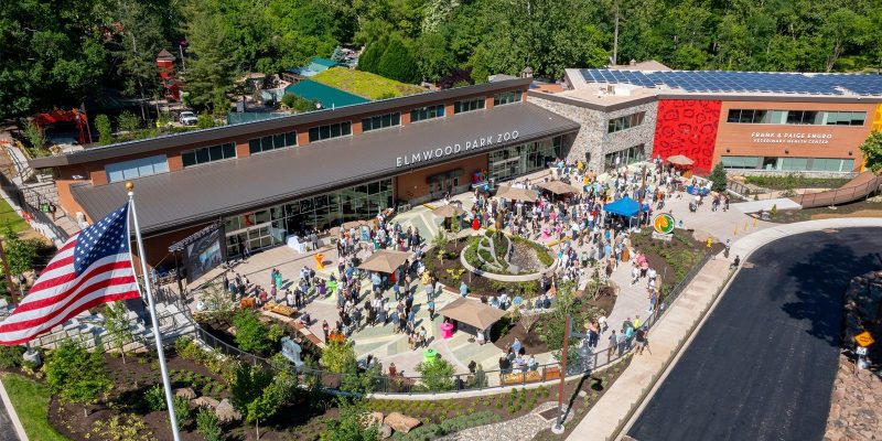 Aerial view of the Elmwood Park Zoo welcome center and veterinary health center with a crowd of visitors on the plaza below