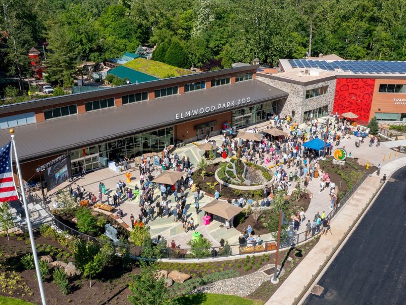 Aerial view of the Elmwood Park Zoo welcome center and veterinary health center with a crowd of visitors on the plaza below