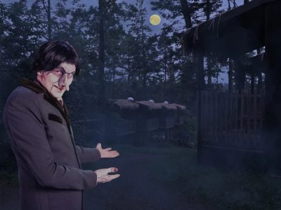 A pale, gaunt undertaker character in a long gray coat gestures toward wooden cabins in a misty moonlit forest.
