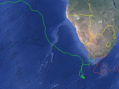 A satellite map of southern Africa and the surrounding oceans with two plotted tracks: a green line running from the southern Cape far up the Atlantic toward West Africa, and an orange line looping east from the Cape across the southwestern Indian Ocean.