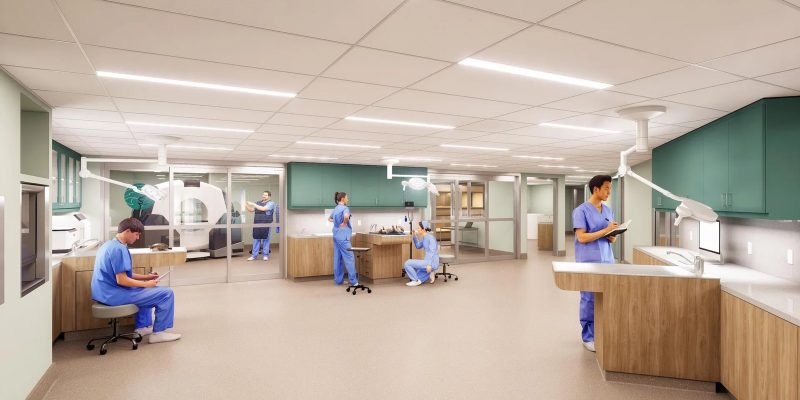 Architectural rendering of the Tennessee Aquarium's planned animal hospital: a bright treatment room with staff in blue scrubs, overhead surgical lights, teal cabinetry and a glass-walled imaging suite holding a CT scanner.