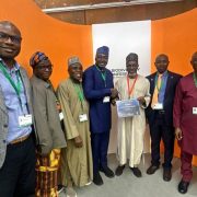 Seven delegates stand together at the CBD COP17 venue in Yerevan, two of them holding a certificate printed with the word Nigeria.