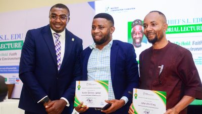 Three men stand for a photograph at the Chief S.L. Edu Memorial Lecture, two of them holding Nigerian Conservation Foundation research grant certificates, in front of a backdrop carrying the foundation's logo and the lecture title.