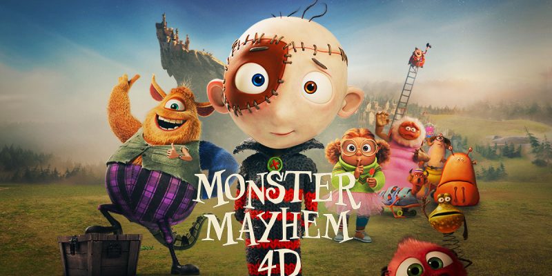Promotional artwork for an animated film, showing a wide-eyed boy character stitched together from patches at center, a shaggy orange monster in purple striped trousers beside him and several smaller cartoon monsters across a green field, with a castle on a rocky crag behind. Lettering reads Monster Mayhem 4D and, above, Are You Ready For Monsters?