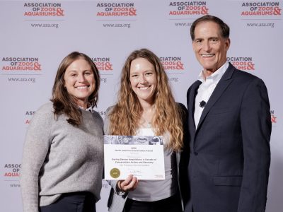 Cassandra Costello, Rochelle Stiles and Dan Ashe stand in front of an Association of Zoos and Aquariums backdrop, with Stiles holding the 2026 North American Conservation Award certificate for San Francisco Zoo and Gardens.