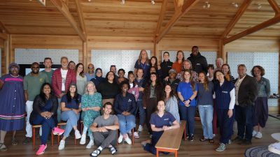 Around forty delegates to the National Sea Turtle Workshop stand and sit together for a group photograph in a timber-framed room at the Two Oceans Aquarium in Cape Town.