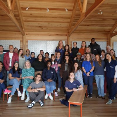 Around forty delegates to the National Sea Turtle Workshop stand and sit together for a group photograph in a timber-framed room at the Two Oceans Aquarium in Cape Town.
